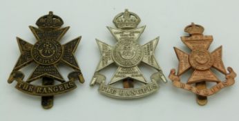 Three British Army 12th County of London Battalion (The Rangers) cap badges including a white