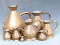Eight graduated copper measuring jugs, four gallons down to one pint and one smaller unmarked likely