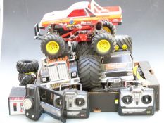 Three remote controlled model monster trucks, some with dual motors and 4-wheel drive together
