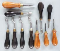 Eleven gun tools comprising flat head screwdrivers and nipple keys, all with wooden handles.