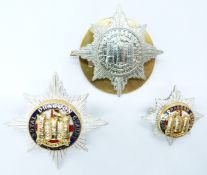 Three British Army Royal Dragoon Guards metal badges including gilt and enamel examples