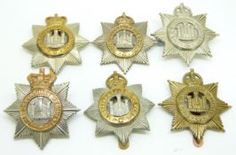 Six British Army Devonshire Regiment metal cap badges including an all brass and Queen Victoria