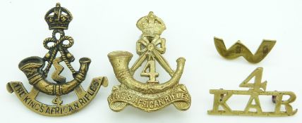 Four 4th King's African Rifles metal badges including an officer's example and shoulder title