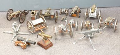 Sixteen various metal model guns and signalling or desk cannon, most on wooden carriages, largest