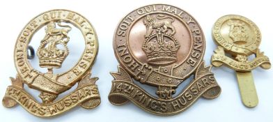 Three British Army 14th King's Hussars metal cap badges including a voided example