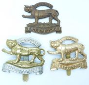 Three British Army Leicestershire Regiment metal hat badges including an all brass example