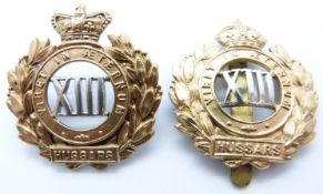 Two British Army 13th Hussars metal cap badges, one with Victoria Crown example
