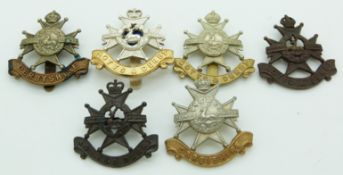 Six British Army Derbyshire Regiment and Notts and Derby Regiment cap badges including officer's,