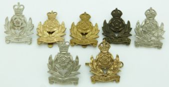 Seven British Army Intelligence Corps metal cap badges including a Queen's Crown example, four by