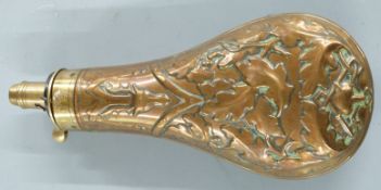 Copper and brass powder flask with embossed decoration of a stag's head, fox mask and oak leaves,
