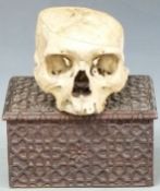 Human skull with top removed and a carved oak stationery box, W22cm