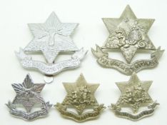 Four Barbados Regiment metal badges comprising two cap badges of different patterns and two collar
