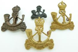 Four 1st King's African Rifles metal badges including an officer's example