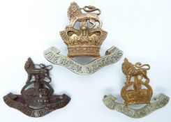 Three British Army Royal Dragoons metal badges including an officer's bronze example