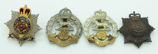 Four British Army Royal Hampshire Regiment metal cap badges including an officer's enamel example