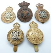 Five British Army 7th Queen's Own Hussars metal cap badges including one all brass and bronze