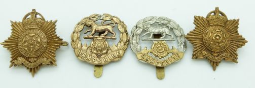 Four British Army Hampshire Regiment metal cap badges including an all brass example