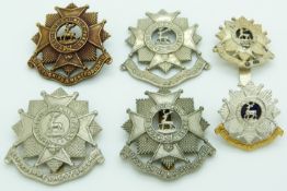 Six British Army Bedfordshire and Hertfordshire Regiment metal cap badges including an officer's