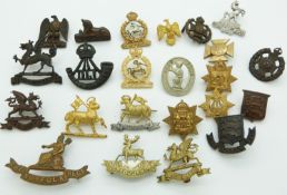 Small collection of British Army metal badges including Essex Regiment, Norfolk Regiment, Buffs,