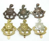 Six British Army Royal Sussex Regiment metal badges including Gaunt and Smith & Wright makers
