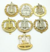 Seven British Army Dorsetshire / Dorset Regiment metal cap badges including a Victorian other