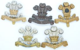 Five British Army 10th Royal Hussars metal cap badges including officer's service dress and an all