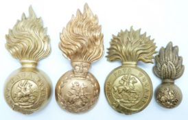 Four British Army Northumberland Fusiliers metal hat badges including fur cap grenade example