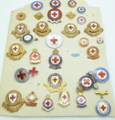 A carded display of thirty two Red Cross enamel badges including county examples for Surrey,
