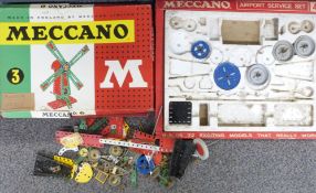 A collection of Meccano pieces together with boxes for Outfit 3 and Airport Service Set 4.