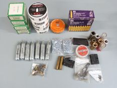 A collection of gun and shooting accessories including snapcaps, CO2 air pistol capsules, 9mm