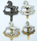 Four British Army King's Liverpool Regiment metal hat badges including an other ranks white metal