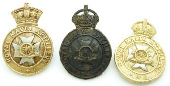 Three British Army Royal Malta Artillery metal cap badges including an officer's service dress and