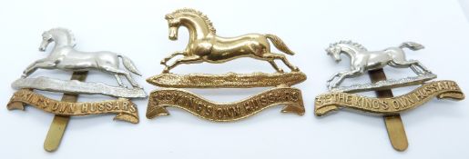 Three British Army 3rd King's Own Hussars metal cap badges including an all brass example