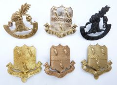 Six Repton College military cap badges including an anodised example and Rugby School Officer