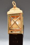 An 18ct gold charm in the form of a lamp set with a pearl, 3.7g