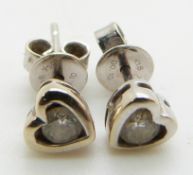 A pair of 18ct white gold heart shaped stud earrings set with a diamond to each, total carat