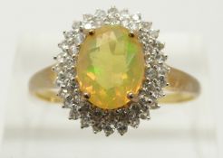 A 9ct gold ring set with an oval cut Indonesian opal surrounded by zircons, 2.3g, size S