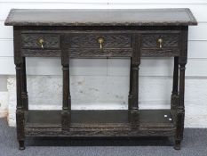 A carved oak hall table with three drawers and undershelf, W95 x D35 x H70cm