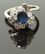 A white gold ring marked 14k set with an oval cut sapphire and diamonds, 4.5g, size J