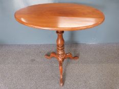 Mahogany oval tilt topped table raised on turned stem and tripod base, W79 x D47 x H70cm