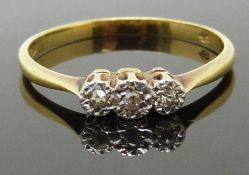 An 18ct gold ring set with three diamonds in a platinum setting, 2.20g