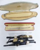 A collection of watches and faux pearls