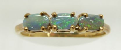 A 9ct gold ring set with three oval black opal cabochons, 1.5g, size N
