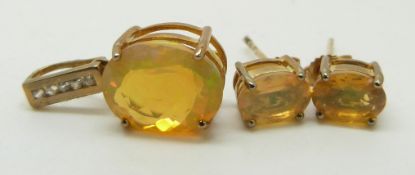 A 9ct gold pendant set with an oval cut opal and matching earrings