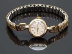Omega 9ct gold ladies wristwatch with gold hands and markers, silver dial and signed 17 jewel