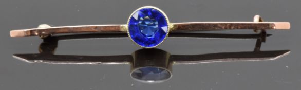 A 9ct gold bar brooch set with a round cut blue stone
