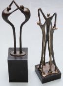 Two Artihove bronzes / bronze sculptures of people linking arms with maker's label to base, one