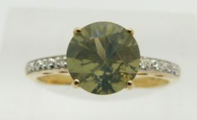 A 9ct gold ring set with a round cut green fire opal and diamonds, 2.2g, size N