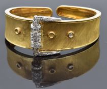 A yellow metal bangle in the form of a buckle set with diamonds, 26.5g