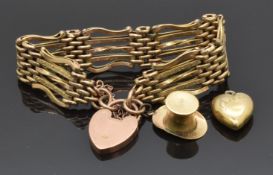 A 9ct gold gate bracelet with heart clasp, a 9ct gold top hat charm and a 9ct gold heart pendant,